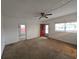 Inviting living room with neutral carpet, ceiling fan, and a front door with decorative glass at 919 Timor Ave, Orlando, FL 32804