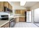 Galley kitchen with stainless steel appliances and wood cabinets at 543 Warrenton Rd # 543, Winter Park, FL 32792