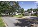 A street view of several homes surrounded by mature trees and lush landscaping on a sunny day at 543 Warrenton Rd # 543, Winter Park, FL 32792