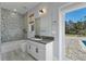 Bathroom with patterned tile, gray vanity, and backyard access at 2972 Crystal Water Run, Oviedo, FL 32765