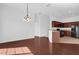 Open dining and kitchen area with hardwood floors, pendant lighting, stainless steel appliances, and view of entryway at 3010 San Jacinto Cir # 3010, Sanford, FL 32771