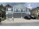 Two-story townhome featuring a light blue facade, three garage doors, and two small balconies at 3010 San Jacinto Cir # 3010, Sanford, FL 32771