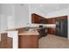 Well-equipped kitchen featuring wood cabinets, black appliances, a breakfast bar, and neutral countertops at 3010 San Jacinto Cir # 3010, Sanford, FL 32771