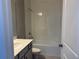 Bright bathroom featuring a shower-tub combo with white tiled walls and gray vanity at 1173 Basalt Ln, Sanford, FL 32771