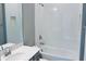 Bathroom showcasing a combined tub and shower, white tile, and a gray vanity with a solid surface countertop at 1173 Basalt Ln, Sanford, FL 32771