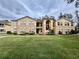 Two-story apartment building in a residential neighborhood featuring landscaped lawn and visible windows at 2878 Club Cortile Cir # A, Kissimmee, FL 34746