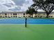 View of a community tennis court featuring new surfacing and dark green fencing at 2878 Club Cortile Cir # A, Kissimmee, FL 34746