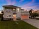 Two-story house with a pink garage door, stone accents, and a landscaped lawn at 4260 S Atlantic Ave, Port Orange, FL 32127