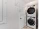 Bright laundry room with stackable washer and dryer and overhead shelving at 4260 S Atlantic Ave, Port Orange, FL 32127
