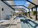 Screened pool and spa with lounge chairs and tropical plants at 4260 S Atlantic Ave, Port Orange, FL 32127