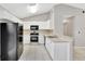 Well-lit kitchen features white cabinetry, tile floors, and modern black appliances at 101 E Division St, Clermont, FL 34711