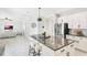 Open kitchen featuring a granite-topped island with seating, stainless steel appliances, and white cabinetry at 2563 Lamar Valley St, Apopka, FL 32703