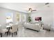 Open-concept living and dining room feature a ceiling fan, neutral furniture, and gray ceramic floors at 2563 Lamar Valley St, Apopka, FL 32703
