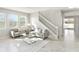Bright living room features two sofas, a glass table, light gray floors, and a staircase at 2563 Lamar Valley St, Apopka, FL 32703