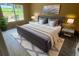 Well-lit bedroom featuring hardwood floors, tufted headboard, and a view of the backyard at 2204 Clementine Trl, Clermont, FL 34714