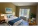 Well-lit bedroom featuring a cozy bed with blue accents and a window overlooking the pool at 2204 Clementine Trl, Clermont, FL 34714