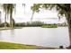 Picturesque lake view featuring a wooded island, with a pier that enhances the natural beauty at 1055 Lake Berkley Dr, Kissimmee, FL 34746