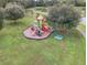 Aerial view of a colorful playground and picnic area surrounded by lush green space near the lake at 1055 Lake Berkley Dr, Kissimmee, FL 34746