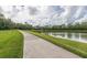 Picturesque view of a paved walking path alongside a serene lake, perfect for leisurely strolls at 1055 Lake Berkley Dr, Kissimmee, FL 34746