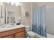 Bright bathroom featuring a toilet, vanity, shower and blue patterned shower curtain at 1473 Moon Valley Dr, Davenport, FL 33896