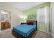 Cozy bedroom featuring a bed with a blue quilt and brightly colored pillows and butterfly artwork at 1473 Moon Valley Dr, Davenport, FL 33896