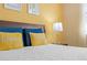 Comfortable bedroom with yellow walls, decorative pillows, and a soft white comforter at 1473 Moon Valley Dr, Davenport, FL 33896