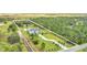 Aerial view showcases the estate home, expansive property, pond, and surrounding green landscape at 4001 Ainsley Ave, Orlando, FL 32833