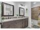 Well lit bathroom with granite countertops, dark wood cabinets, and dual sinks at 4001 Ainsley Ave, Orlando, FL 32833