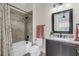 Bathroom boasts granite vanity and shower/tub combo with unique tile accent and floral shower curtain at 4001 Ainsley Ave, Orlando, FL 32833