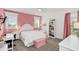 Bright bedroom featuring a bed, desk, shelves, and a pink accent wall at 4001 Ainsley Ave, Orlando, FL 32833