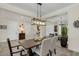 Open-concept dining area with a stylish chandelier, seating for six, and elegant decor at 4001 Ainsley Ave, Orlando, FL 32833