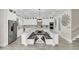 Elegant white kitchen with custom cabinets, granite countertops, stainless steel appliances, and a unique dining island at 4001 Ainsley Ave, Orlando, FL 32833