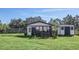 Exterior view of a modern outbuilding with fencing and an adjacent storage shed in a lush green yard at 4001 Ainsley Ave, Orlando, FL 32833