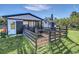 A fenced enclosure adjoins a modern outbuilding with an adjacent shed in a yard with green grass at 4001 Ainsley Ave, Orlando, FL 32833