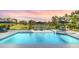 Beautiful pool with a spa, umbrellas, and chairs, next to a pond, providing a relaxing outdoor experience at 4001 Ainsley Ave, Orlando, FL 32833