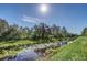 Scenic waterfront featuring lush greenery, mature trees, and vibrant lily pads on a serene waterway at 4001 Ainsley Ave, Orlando, FL 32833