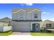 Charming two-story home with a gray exterior, brick paver driveway, and well-manicured front lawn at 7247 Rolling Leaf Rd, Groveland, FL 34736