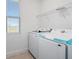 Laundry room with white washer and dryer, wire shelving, and natural light at 7247 Rolling Leaf Rd, Groveland, FL 34736