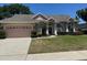 Inviting single-story home with a well-manicured lawn and a two-car garage at 1833 Queen Palm Dr, Apopka, FL 32712