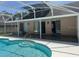 Back of home showing screened in pool area, sliding doors, and roof at 1833 Queen Palm Dr, Apopka, FL 32712