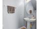 Powder room features a modern pedestal sink and a round mirror at 1911 Betsy Ross Ln, St Cloud, FL 34769