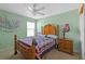 Quaint bedroom with colorful walls, a wooden bed frame, ceiling fan and matching nightstand at 1911 Betsy Ross Ln, St Cloud, FL 34769