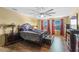 Bedroom featuring a large wood bed frame, ceiling fan, wood floors, television, and window views at 1911 Betsy Ross Ln, St Cloud, FL 34769