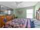 Bedroom featuring a large bed, television, wood floors, ceiling fan and window views at 1911 Betsy Ross Ln, St Cloud, FL 34769