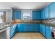 Modern kitchen featuring blue cabinets, tile backsplash, and stainless steel appliances at 1911 Betsy Ross Ln, St Cloud, FL 34769