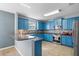 Bright kitchen featuring blue cabinetry, stainless steel appliances, and a stylish backsplash at 1911 Betsy Ross Ln, St Cloud, FL 34769