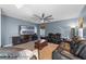Comfortable living room showcases a large flat screen TV, coffered ceiling fan, and leather reclining sofas at 1911 Betsy Ross Ln, St Cloud, FL 34769