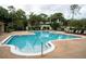 Community swimming pool with poolside chairs and decorative pergola surrounded by lush tropical foliage at 2624 Robert Trent Jones Dr # 623, Orlando, FL 32835