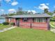 Charming single-story brick home with a fenced-in front porch and well-maintained lawn, presenting curb appeal at 1904 Historic Goldsboro Blvd, Sanford, FL 32771