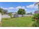 Fenced backyard with a shed, green grass, and mature tree offers a private outdoor space at 1957 Teaberry Ct, Orlando, FL 32824